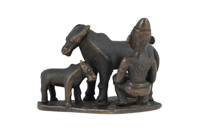 Lot 177 - A CAST BRONZE FIGURINE WITH A COWHERD MILKING A COW