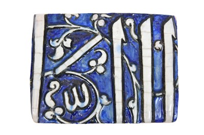 Lot 231 - A MOULDED CALLIGRAPHIC POTTERY TILE FRAGMENT