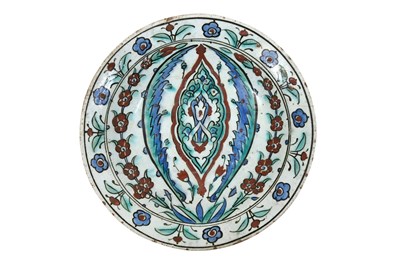 Lot 133 - AN IZNIK POTTERY DISH WITH ARABESQUE, SAZ LEAVES, AND FLORAL DECORATION