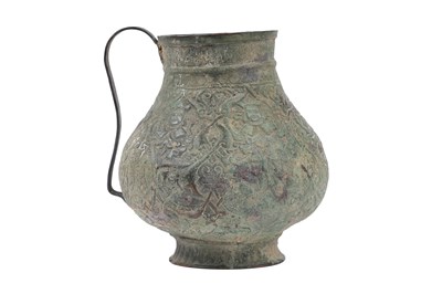 Lot 28 - AN EMBOSSED COPPER JUG WITH MYTHICAL CREATURES AND KUFIC CALLIGRAPHY