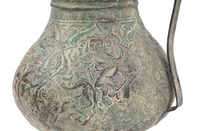 Lot 28 - AN EMBOSSED COPPER JUG WITH MYTHICAL CREATURES AND KUFIC CALLIGRAPHY