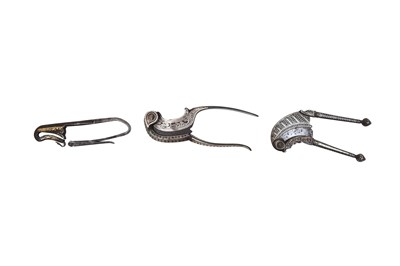 Lot 31 - TWO SILVER-DAMASCENED (KOFTGARI) STEEL BETEL NUTCRACKERS AND A GOLD-DAMASCENED STEEL FLINT STRIKER